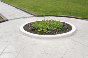 flower bed surrounded by stamped concrete