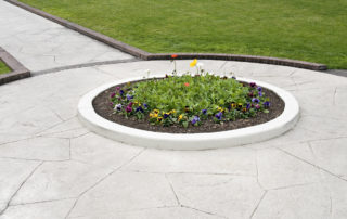 flower bed surrounded by stamped concrete